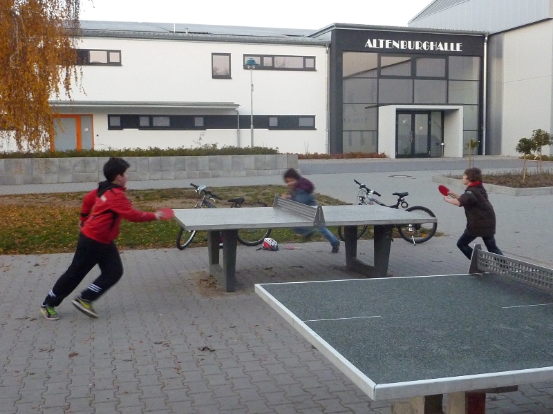 Tischtennistische mit spielenden Jugendlichen vor der Altenburghalle