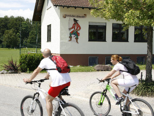 Zwei Fahrradfahrer fahren an der Seeräuberschenke vorbei